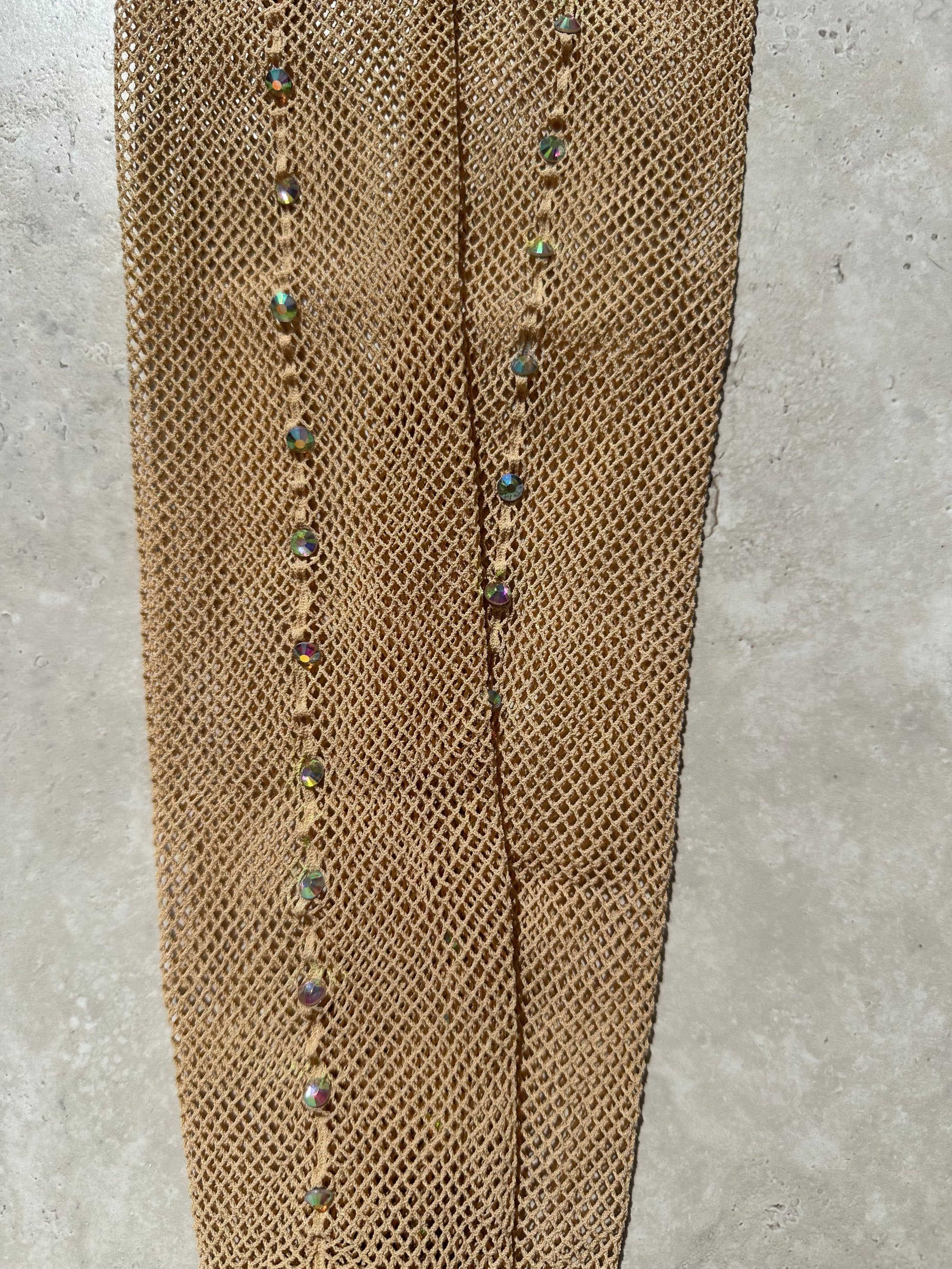 A pair of light tan fishnet tights with a back seam full of AB diamantés.