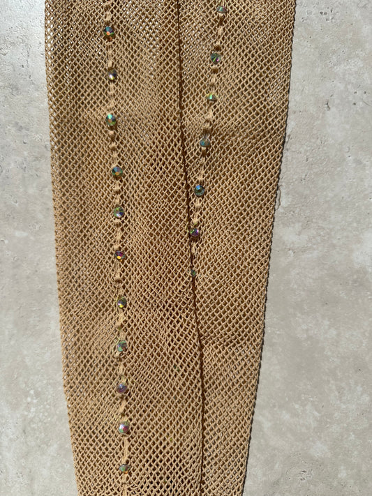 A pair of light tan fishnet tights with a back seam full of AB diamantés.
